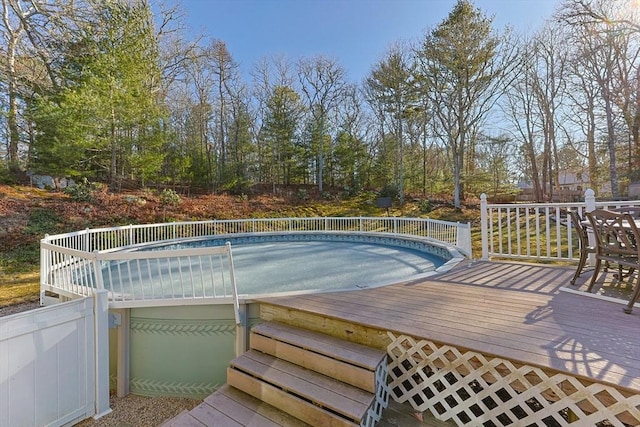 view of pool featuring fence and a deck