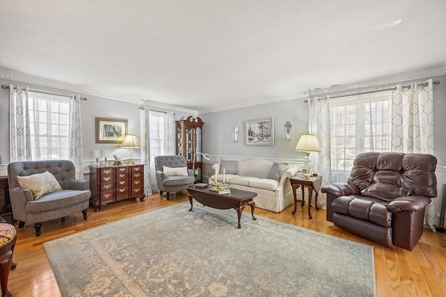 living area with crown molding and wood finished floors