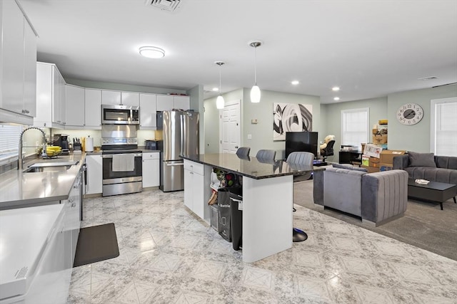 15 Bunker St Unit 2, Boston, MA 02136 - kitchen featuring stainless steel appliances, a sink, white cabinetry, dark countertops, and a center island