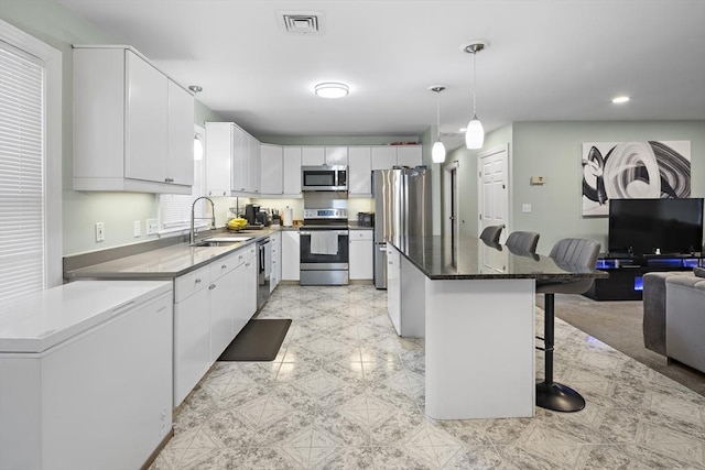 15 Bunker St Unit 2, Boston, MA 02136 - kitchen featuring stainless steel appliances, a sink, a kitchen breakfast bar, a center island, and white cabinetry