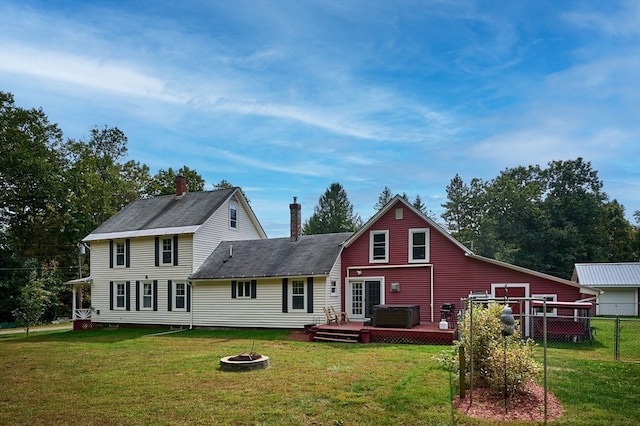 rear view of house featuring a lawn, an outdoor fire pit, and a wooden deck