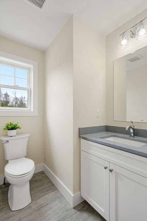 53 Driftwood Cir Unit 20, Sandown, NH 03873 - bathroom with baseboards, vanity, toilet, and wood finished floors