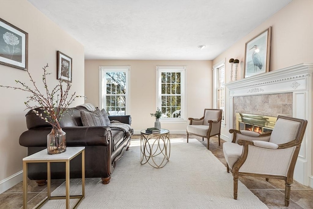 living room with a tiled fireplace and a healthy amount of sunlight