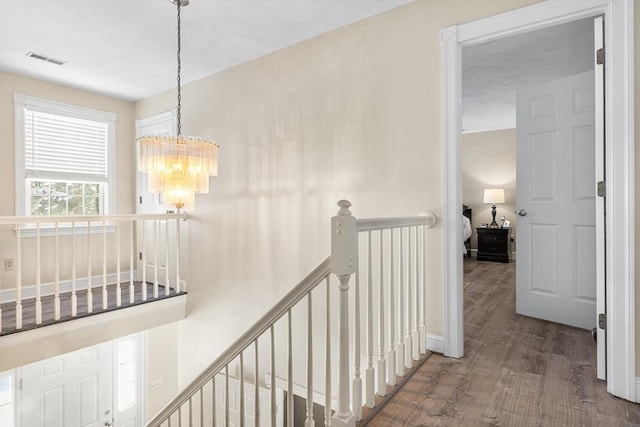 hall featuring a chandelier and hardwood / wood-style floors