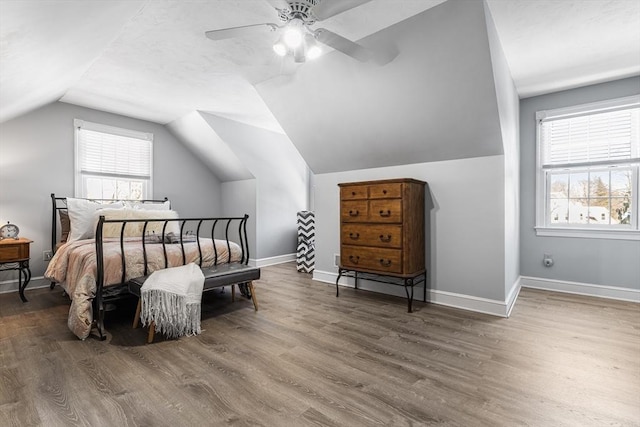 bedroom with ceiling fan, wood-type flooring, and vaulted ceiling