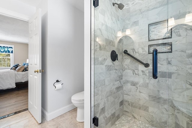 bathroom with tile patterned floors, toilet, and a shower with shower door