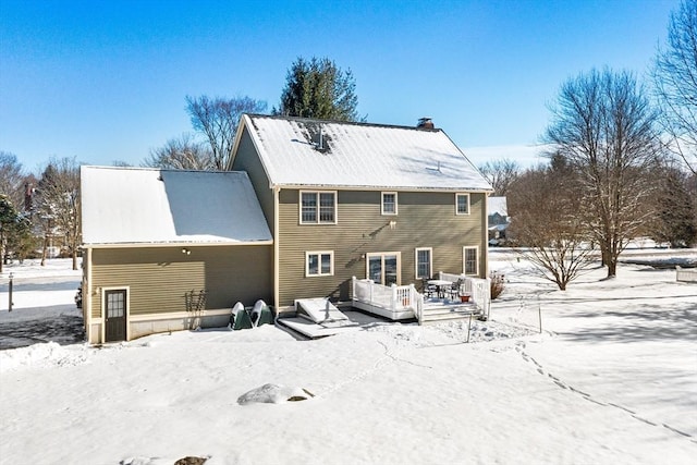 snow covered house featuring a deck