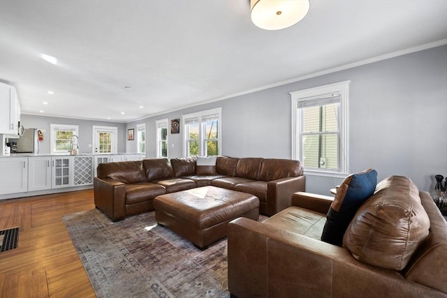 living room featuring crown molding, a healthy amount of sunlight, and dark hardwood / wood-style floors