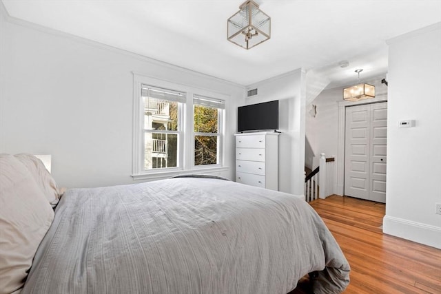 bedroom featuring wood-type flooring, a closet, and crown molding