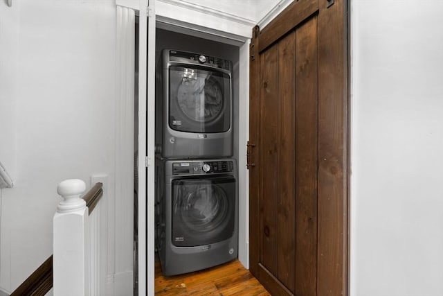 washroom featuring light hardwood / wood-style floors and stacked washer / dryer