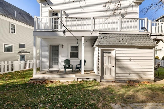 rear view of house featuring a yard and a balcony