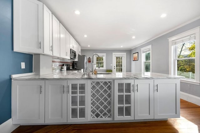 kitchen with kitchen peninsula, white cabinetry, and stainless steel appliances