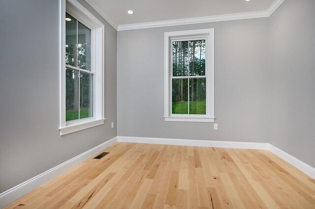 spare room with hardwood / wood-style floors and crown molding