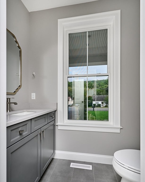 bathroom with vanity, toilet, and tile patterned floors