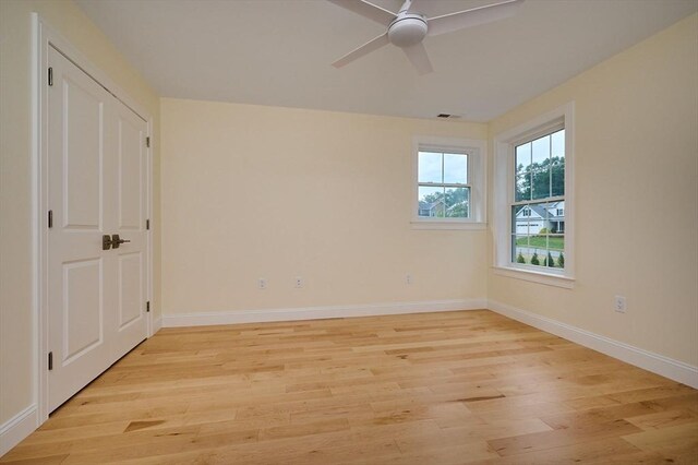 empty room with ceiling fan and light hardwood / wood-style floors