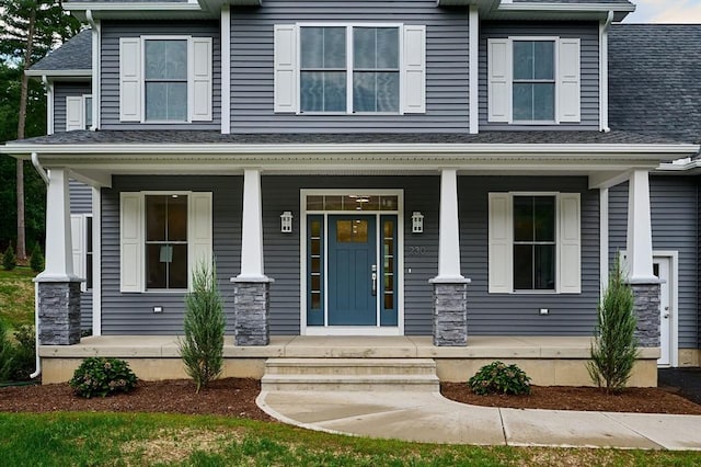 craftsman-style house with covered porch and a shingled roof