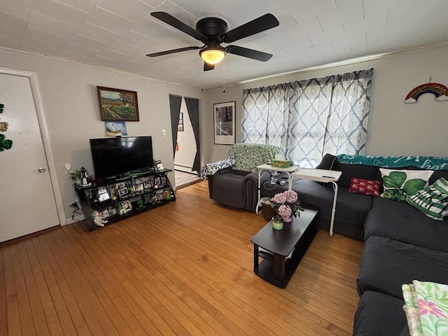 living room featuring light wood finished floors and a ceiling fan