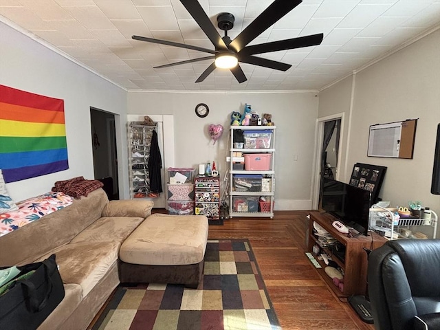 living area with wood finished floors, ceiling fan, and ornamental molding