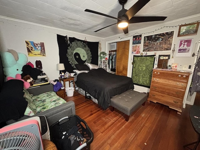 bedroom with a ceiling fan, crown molding, and wood finished floors