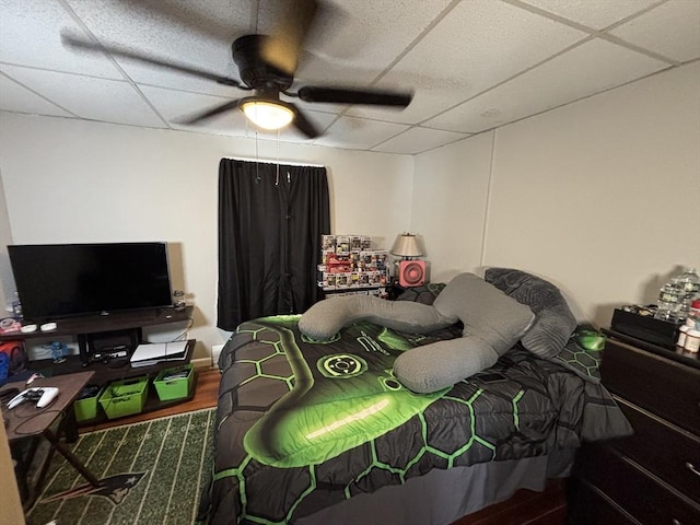 bedroom with a paneled ceiling and a ceiling fan