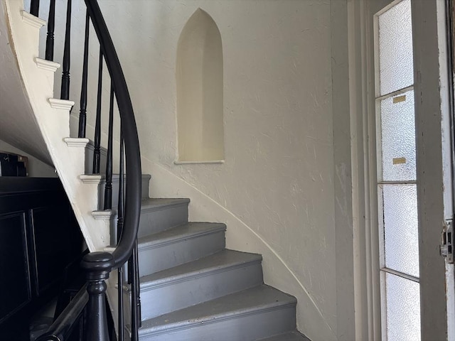 stairway featuring a textured wall