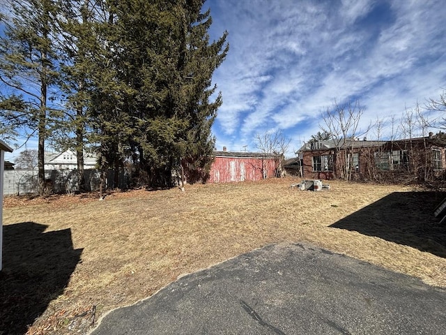 view of yard featuring an outdoor structure and fence