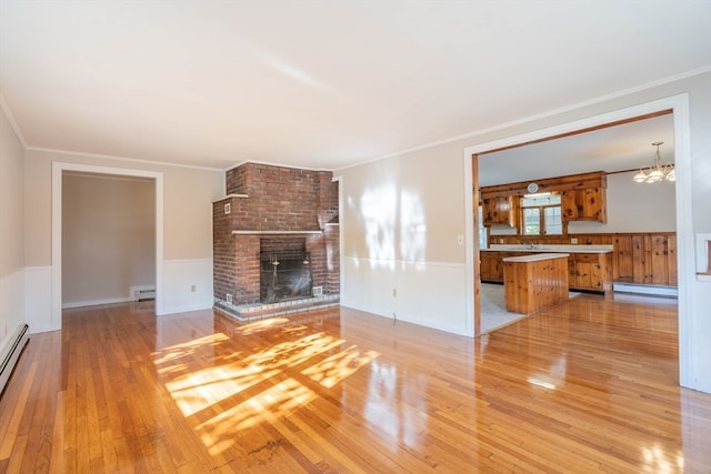 unfurnished living room with a fireplace, light wood-type flooring, and a baseboard radiator