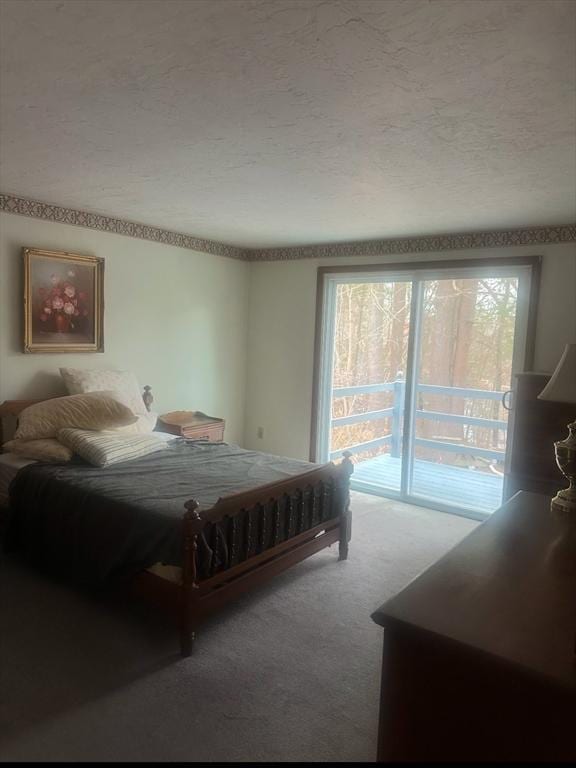 carpeted bedroom with a textured ceiling and access to exterior