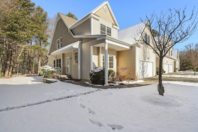 view of snow covered exterior with a garage and a porch