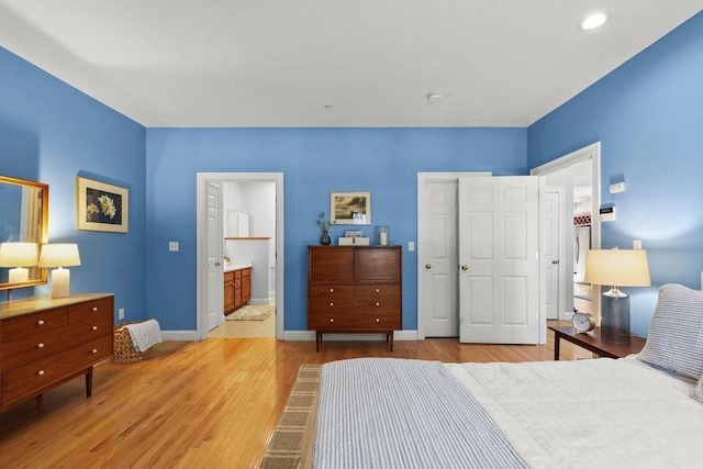 bedroom with connected bathroom, a closet, and light wood-type flooring