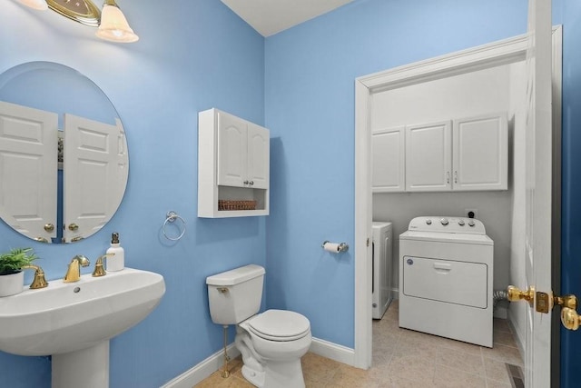 bathroom with tile patterned floors, toilet, washer and clothes dryer, and sink