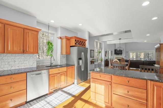 kitchen with pendant lighting, sink, appliances with stainless steel finishes, a notable chandelier, and decorative backsplash