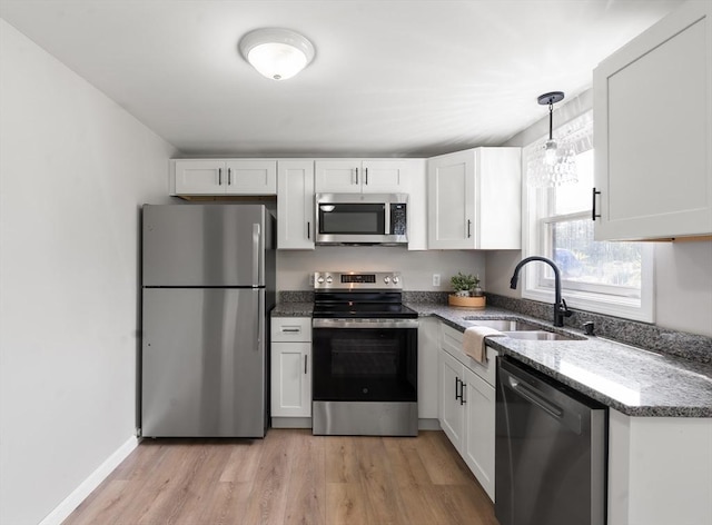 742 Daniel Shays Hwy Unit 1F, Athol, MA 01331 - kitchen featuring stainless steel appliances, light stone countertops, light wood-style flooring, white cabinetry, and decorative light fixtures