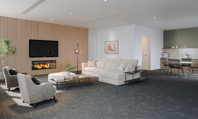 living area with dark carpet, a glass covered fireplace, and recessed lighting