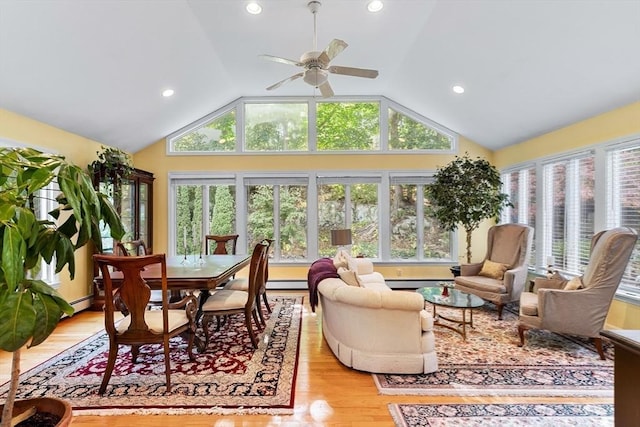 sunroom / solarium featuring lofted ceiling, wood finished floors, a wooden deck, a baseboard radiator, and recessed lighting