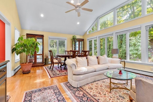 living area with high vaulted ceiling, ceiling fan, recessed lighting, a baseboard radiator, and light wood-type flooring