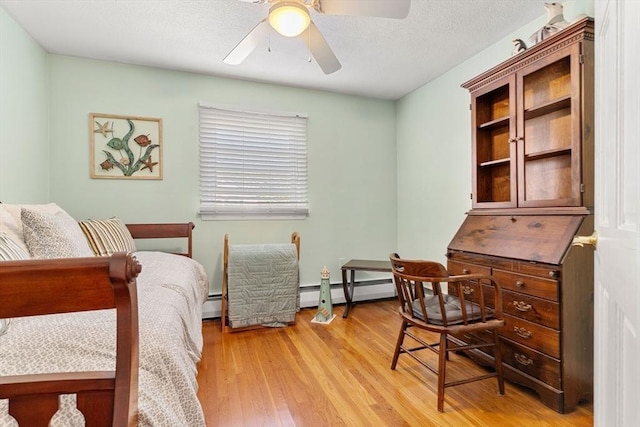 bedroom featuring light wood-style floors, a baseboard radiator, and a ceiling fan