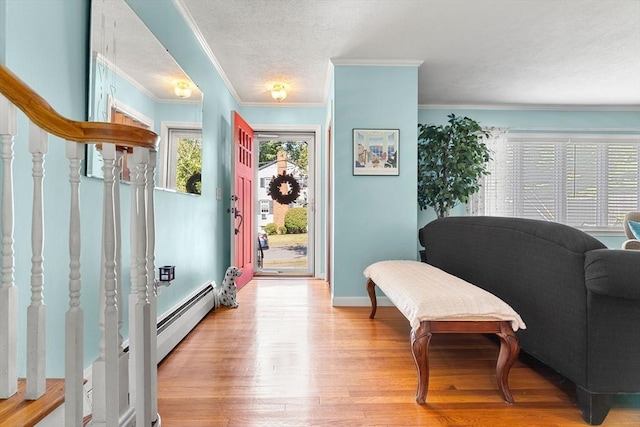 sitting room with wood finished floors, crown molding, stairs, and baseboards