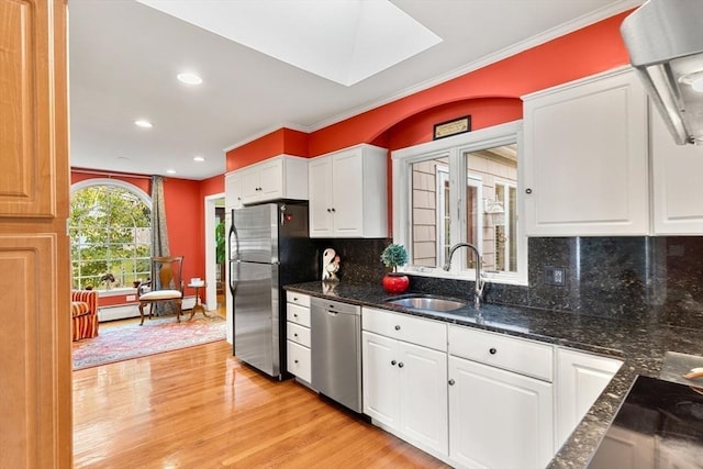 kitchen with stainless steel appliances, a sink, white cabinetry, ornamental molding, and recessed lighting