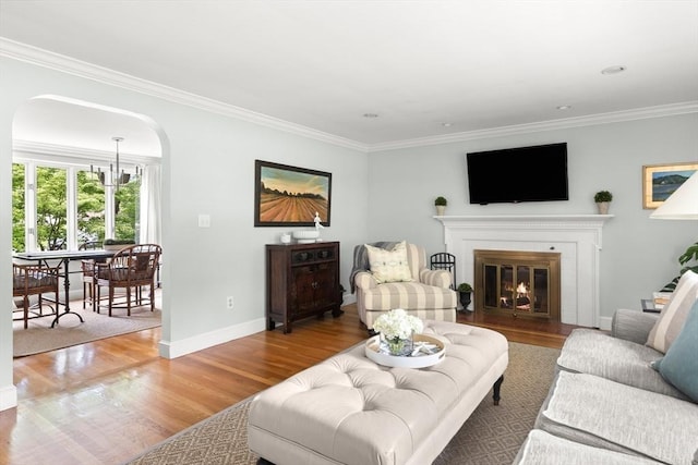 56 Postgate Rd, Hamilton, MA 01982 - living room with arched walkways, ornamental molding, wood finished floors, baseboards, and a glass covered fireplace