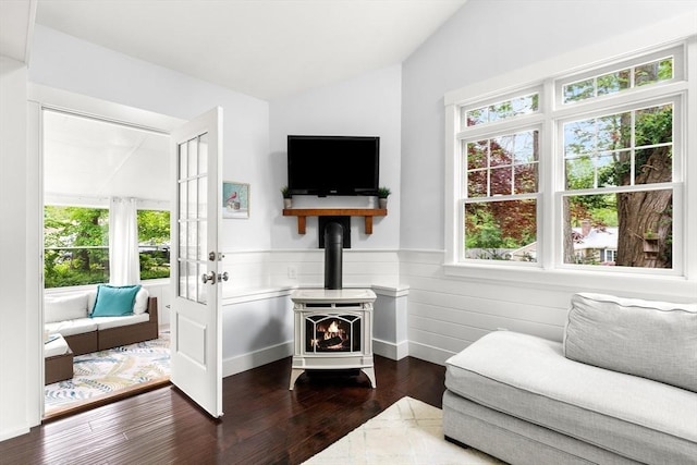 56 Postgate Rd, Hamilton, MA 01982 - living area featuring a wood stove, vaulted ceiling, plenty of natural light, a wainscoted wall, and dark wood-style floors