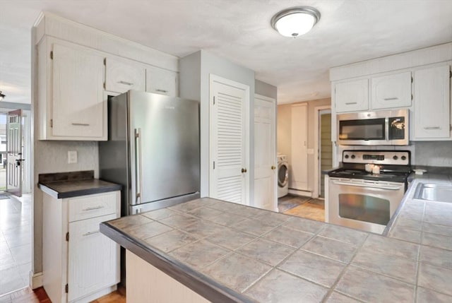 10 Emile Cir, Malden, MA 02148 - kitchen with stainless steel appliances, washer / clothes dryer, white cabinetry, and a sink