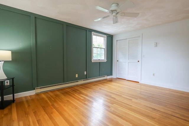 10 Emile Cir, Malden, MA 02148 - unfurnished bedroom featuring a baseboard heating unit, light wood-style floors, baseboards, and a ceiling fan