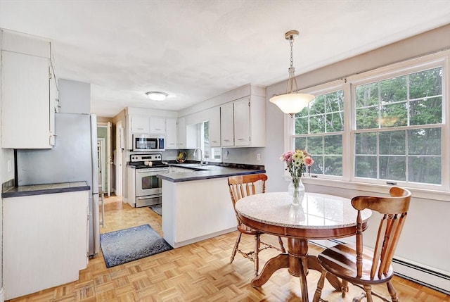 10 Emile Cir, Malden, MA 02148 - kitchen featuring appliances with stainless steel finishes, dark countertops, a peninsula, and a baseboard heating unit