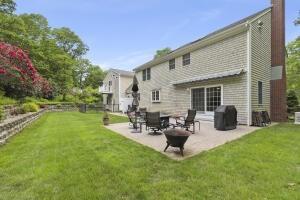 5 Lancaster Ln, Bourne, MA 02532 - back of property with a patio area, a chimney, and a yard