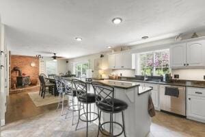 5 Lancaster Ln, Bourne, MA 02532 - kitchen featuring dishwasher, dark countertops, a breakfast bar, a kitchen island, and a ceiling fan