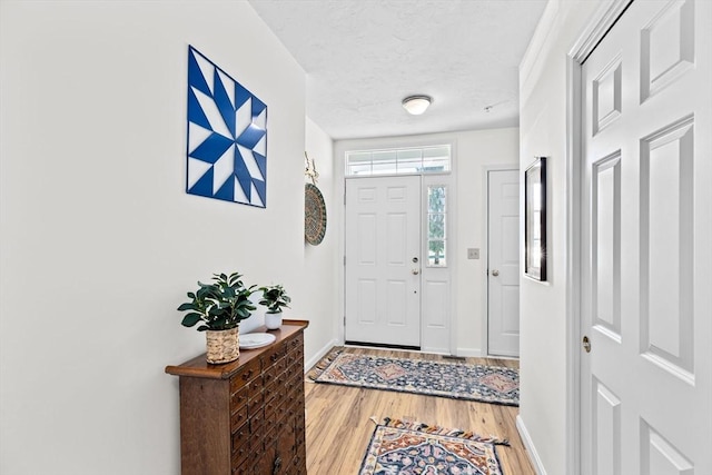 foyer entrance with hardwood / wood-style floors and a textured ceiling