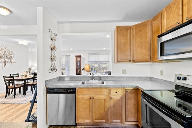 kitchen featuring hardwood / wood-style floors, appliances with stainless steel finishes, and sink