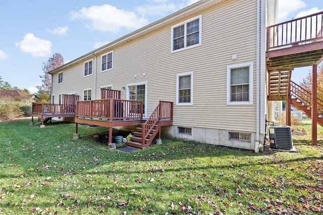 rear view of property featuring a lawn, central AC unit, and a deck