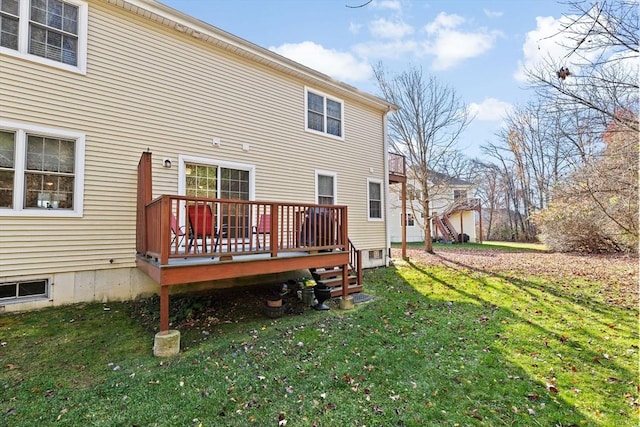 back of property featuring a wooden deck and a yard